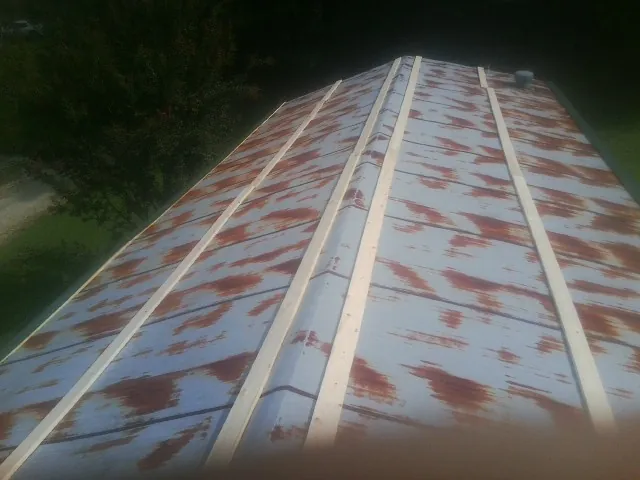 Rusted metal roof panels with new wood purlins before replacement — Storm Damage Roof Repair in Friendsville by Roofing Brothers